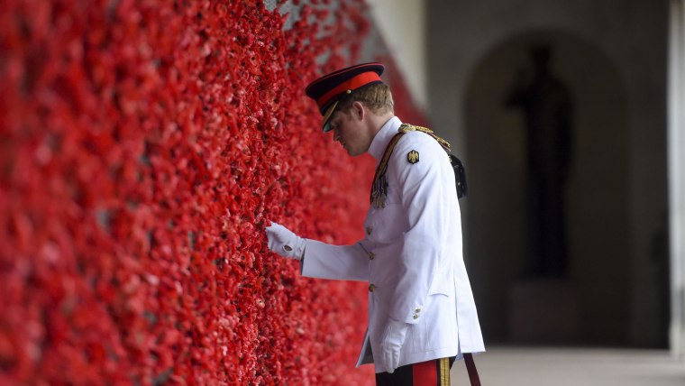 Prince Harry places a poppy at the Roll of Honour.