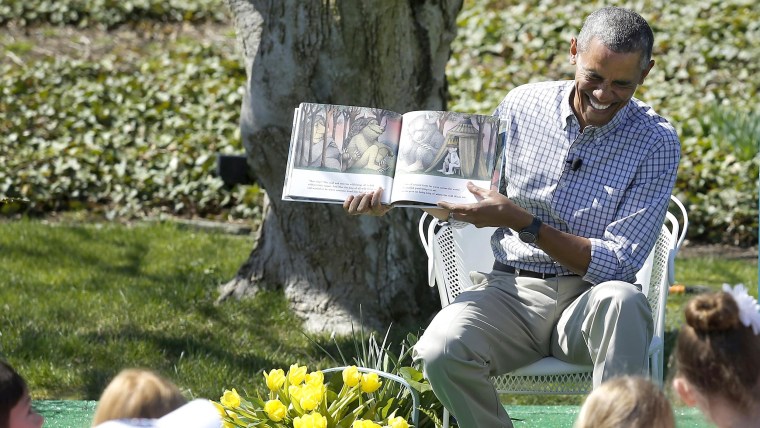 President Barack Obama laughs as he reads the storybook "Where the Wild Things Are" during the annual Easter Egg Roll at the White House in Washington