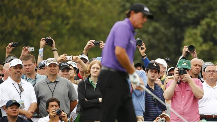 Golf patrons work to get a picture of Phil Mickelson during his practice round ahead of the 2015 masters.