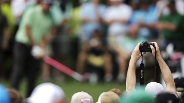 A spectator takes a photo of Bubba Watson during a practice round for the Masters golf tournament Tuesday, April 7, 2015, in Augusta, Ga. (AP Photo/Ma...