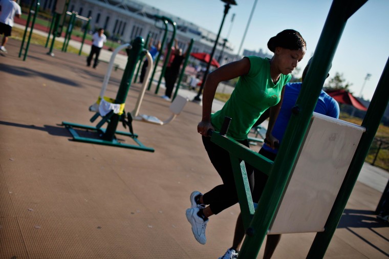 Image: A woman works out in an outdoor exercise area at Macombs Dam Park in the Bronx section of New York City