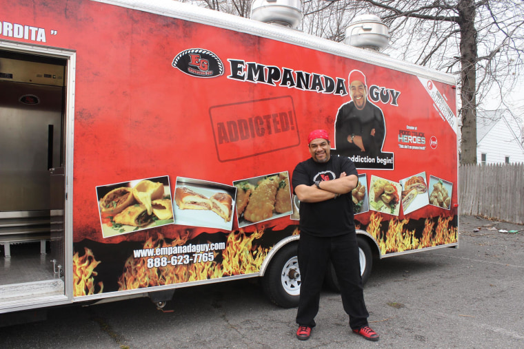 The “Empanada Guy,” Carlos Serrano, poses with one of his food trucks.