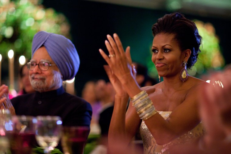 First Lady Michelle Obama claps during the entertainment portion of the State Dinner for Prime Minister Manmohan Singh of India, left,  and his wife, Mrs. Gursharan Kaur, held in a tent on the South Lawn of the White House, Nov. 24, 2009.