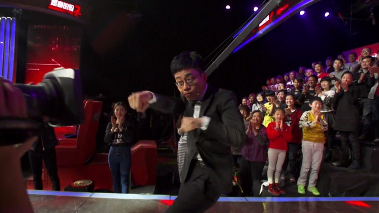 Image: Comedian Joe Wong makes am entrance during the taping of his show in Beijing.