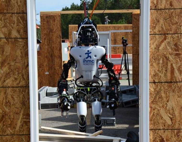 An IHMC Robotics robot makes its way across a debris field in the last Robotics Challenge, in 2013.