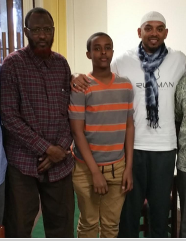 (L-R) Abdullahi Mohamud, father of Abdisamad Sheikh-Hussein, a 15-year old boy who was killed last December, stands next to another son, and Jameel Syed in a mosque in Kansas City, Missouri