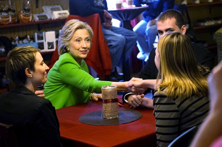 Image: Former U.S. Secretary of State Clinton talks with local residents as she campaigns at the Jones Street Java House in LeClaire, Iowa