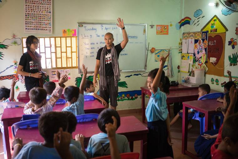 Image:  Ron Ung teaches a group of kids how to use a digital camera in one of the school supported by YMCA located in a poor neighborhood of Phnom Penh.