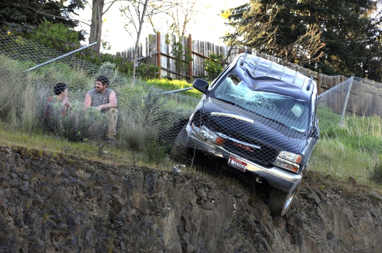 Jason Warnock talks with 23-year-old driver Mathew Sitko after Warnock pulled him from an SUV stopped by a chain link fence just short of a vertical drop in Lewiston, Idaho, on April 15.