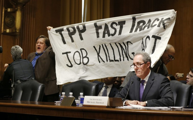 Image: TPP protester holds up a sign during Froman trade hearing on Capitol Hill in Washington