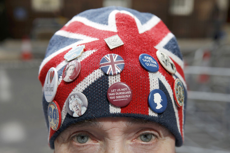 A fan of the royal family wears a union jack hat decorated with badges outside the Lindo Wing of St Mary's hospital in London