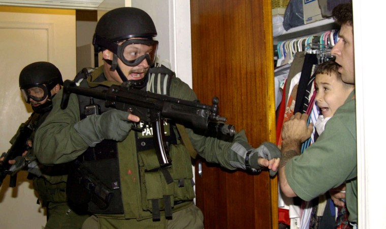 Image: Elian Gonzalez is held in a closet by Donato Dalrymple, one of the two men who rescued the Cuban boy from the ocean