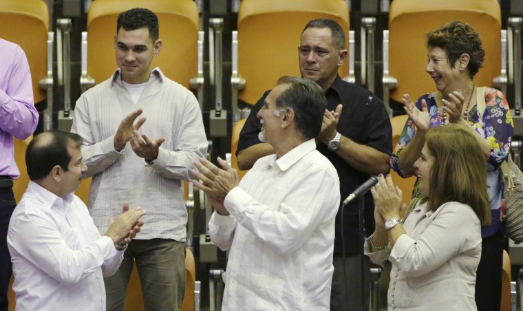 Image: Cuban shipwreck survivor Elian Gonzalez stands with two of the so-called "Cuban Five" Fernando Gonzalez and Rene Gonzalez while attending the Cuban National Assembly in Havana
