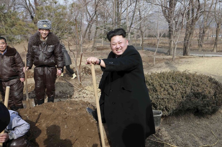 Image: North Korean leader Kim smiles as he plants trees with fighter pilots from Unit 447 of the KPA Air and Anti-Air Force honoured with the title of O Jung Hup-led 7th Regiment
