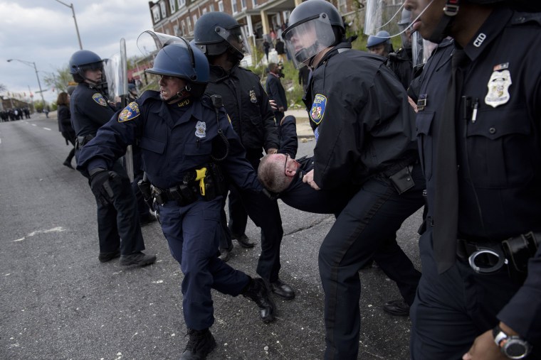 Image: Baltimore police officers carry an injured comrade