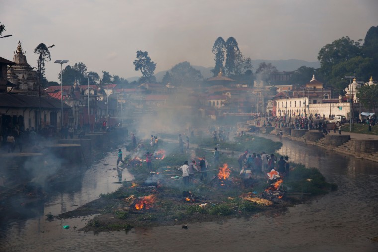 Flames rise from burning funeral pyres during the cremation of victims of Saturday's earthquake, at the Pashupatinath temple on the banks of Bagmati river, in Kathmandu, Nepal, Sunday, April 26, 2015. The earthquake centered outside Kathmandu, the capital, was the worst to hit the South Asian nation in over 80 years. It destroyed swaths of the oldest neighborhoods of Kathmandu, and was strong enough to be felt all across parts of India, Bangladesh, China's region of Tibet and Pakistan.(AP Photo/Bernat Armangue)