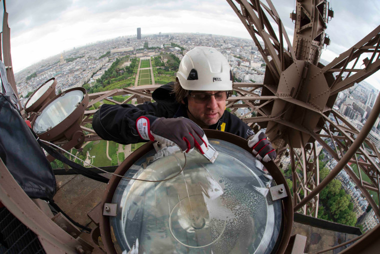 Image: Technician David Kalic cleans one of the sodium golden light bulbs on the Eiffel tower in Paris, France