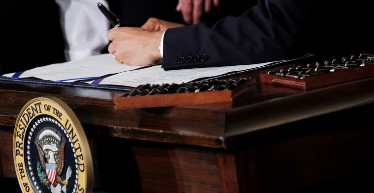 Image: Barack Obama signs the health care reform bill
