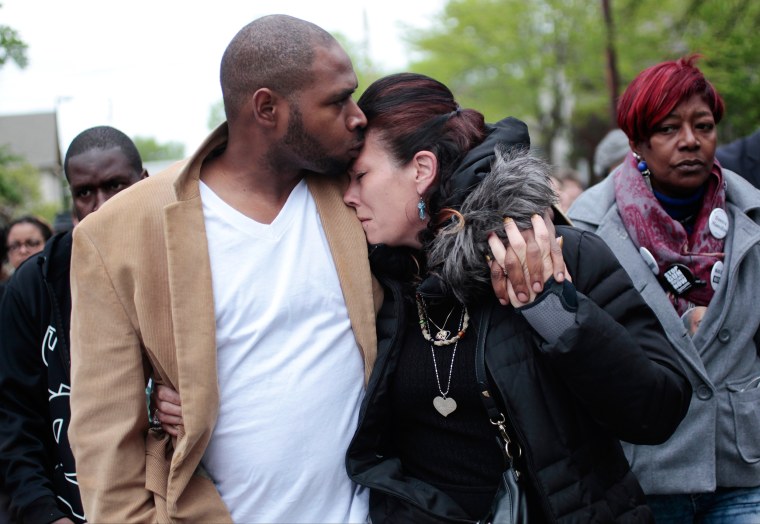 Image: Jeff Jackson, left, comforts his girlfriend, Andrea Irwin, the mother of Tony Robinson