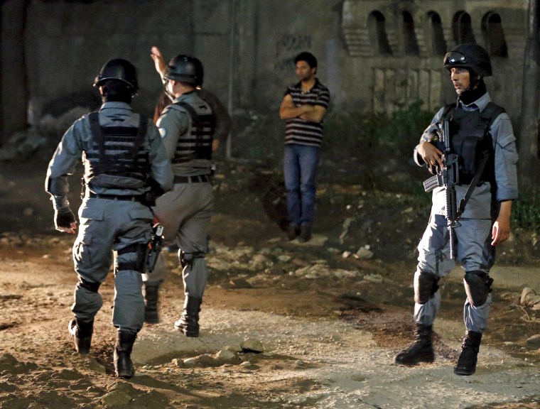 Image: Afghan policemen keep watch at the site of an attack in Kabul