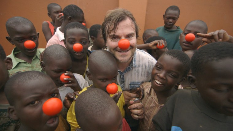 Jack Black wears a red nose alongside children in a slum in Uganda to raise awareness of kids living in poverty