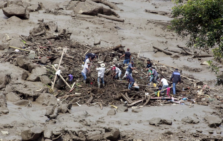 Image: Residents remove mud and debris as they search for bodies after a landslide in the municipality of Salgar, in Antioquia department