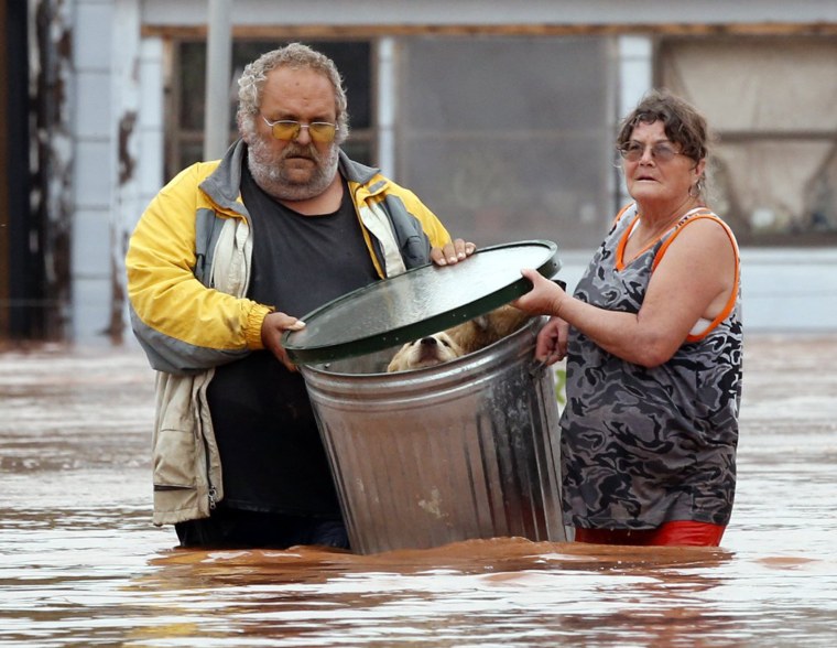 Image: George and Susan Kruger make one of three trips with their animals from their flooded house to safety on Sunday, May 24, 2015 in Purcell, Okla.