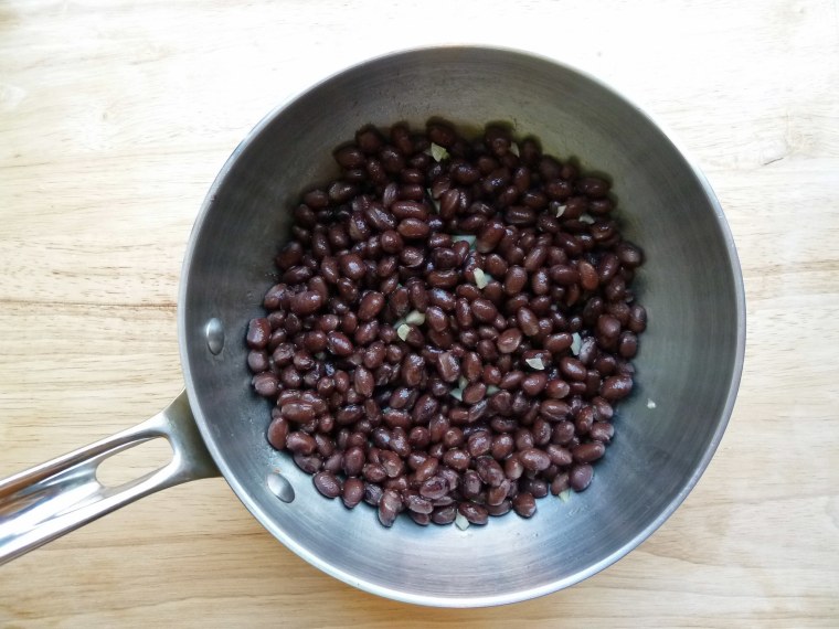 Black beans in pan for freezer breakfast burrito