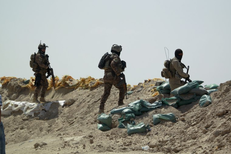 Image: Iraqi government forces walk in the Jurf al-Sakher area south of Baghdad