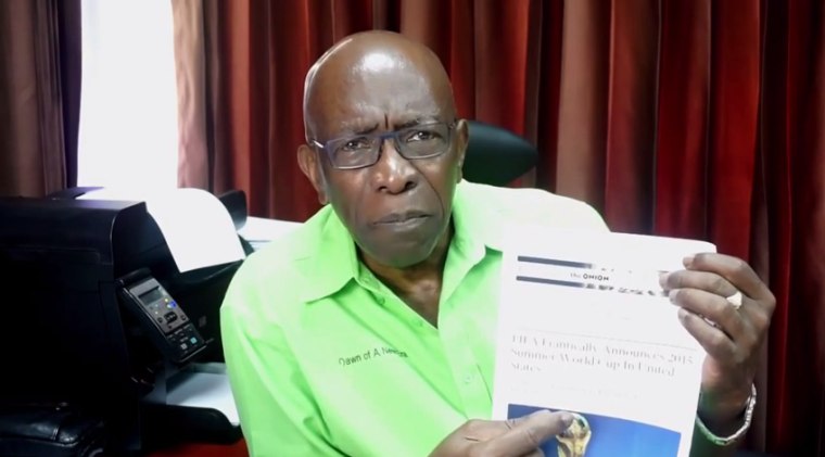 Former FIFA official Jack Warner holds up an article from the Onion, satirical paper that said the World Cup would be held in the United States in 2015 instead of in RUssia in 2018.