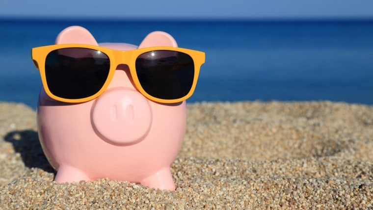 Summer piggy bank with sunglasses on the beach;