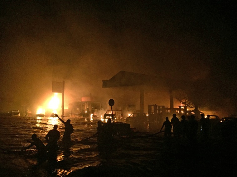 Firefighters and members of the public try to rescue survivors and douse the fire after a gas station in Ghana's capital blew up while many people were sheltering there from torrential rainfall and flooding.