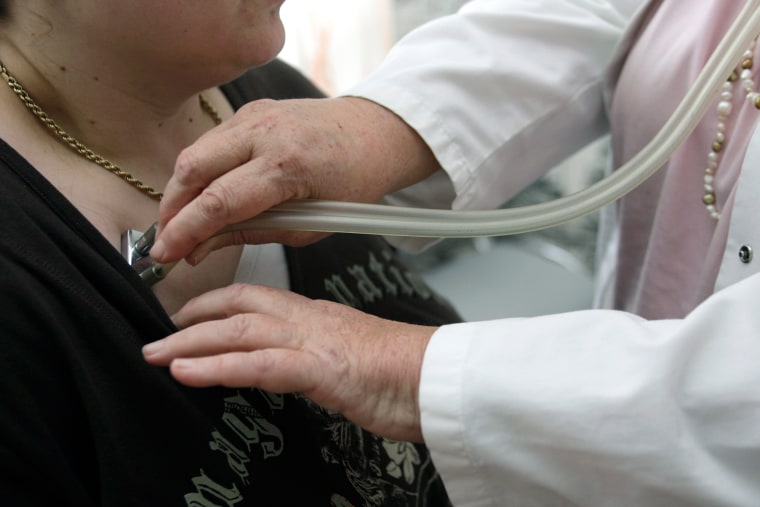 Image: A doctor auscultates a patient with a stethoscope