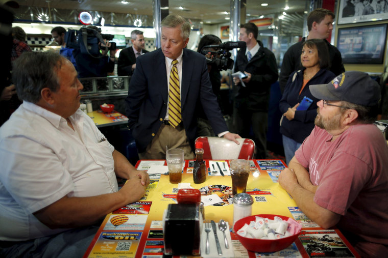 Image: Republican presidential candidate U.S. Senator Lindsey Graham (C) (R-SC) talks to diners during a campaign stop at MaryAnn's Diner in Derry