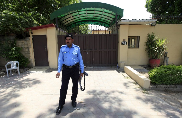 Image: A police officer stands guard outside Save the Children's office in Islamabad