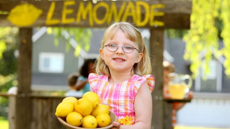 Girl holding bowl of lemons