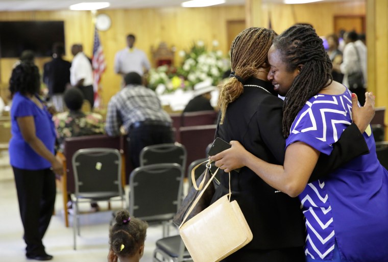 Image: Waltrina Middleton, right, cousin of shooting victim DePayne Doctor, embraces Claudia Lawton