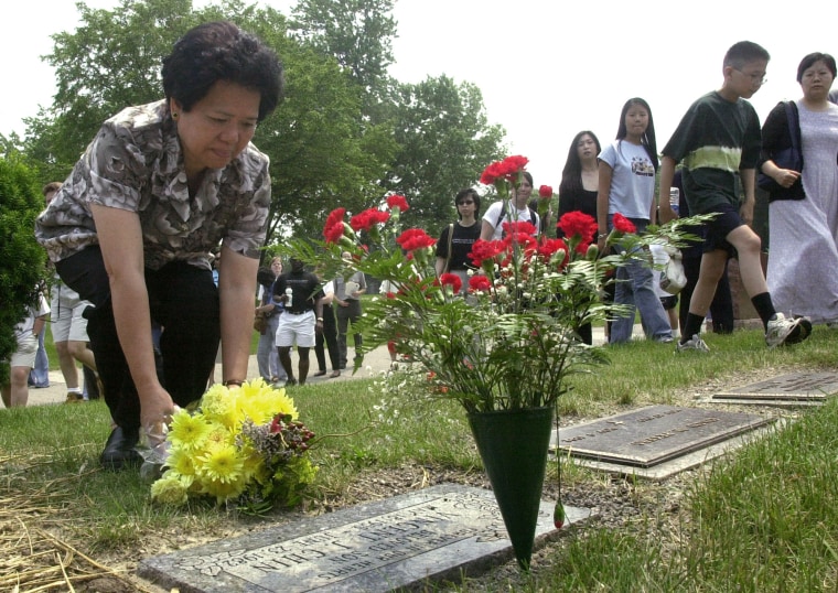 Amy Lee places flowers at the grave stone of her nephew, Vincent Chin.