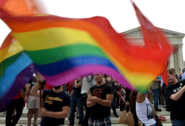 People wave a multicolored flag outside the Supreme Court in Washington, DC on June 26, 2015 after its historic decision on gay marriage. The US Supreme Court ruled Friday that gay marriage is a nationwide right, a landmark decision in one of the most keenly awaited announcements in decades and sparking scenes of jubilation. The nation's highest court, in a narrow 5-4 decision, said the US Constitution requires all states to carry out and recognize marriage between people of the same sex. AFP PHOTO/ MLADEN ANTONOVMLADEN ANTONOV/AFP/Getty Images