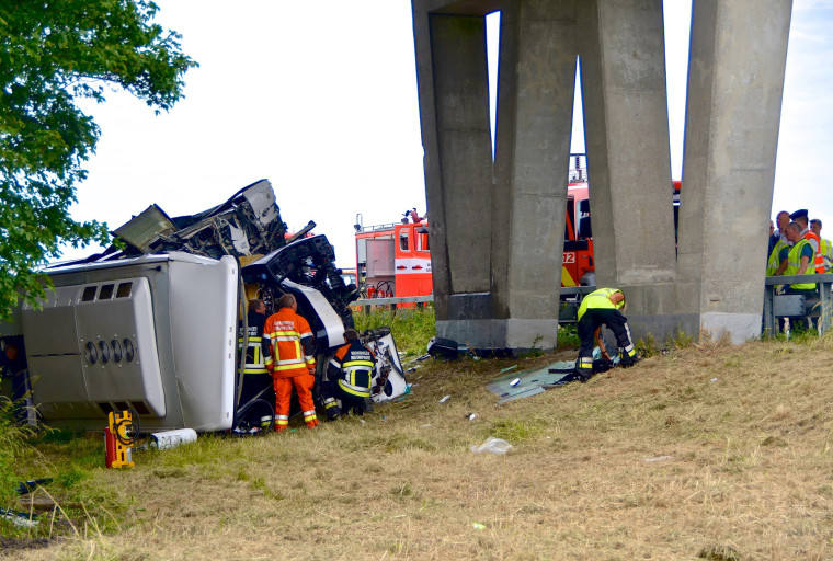 Image: Rescuers stand next to a British bus, transporting 34 children and which overturned and crashed on a motorway near the city of Middelkerke
