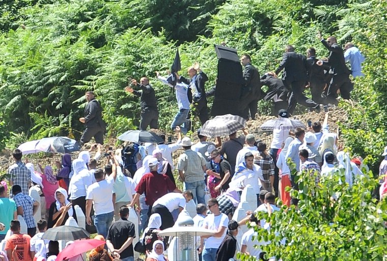 Image: Serbian Prime Minister Alexandar Vucic and his delegation, escorted by security forces, leave the Potocari Memorial Cemetery