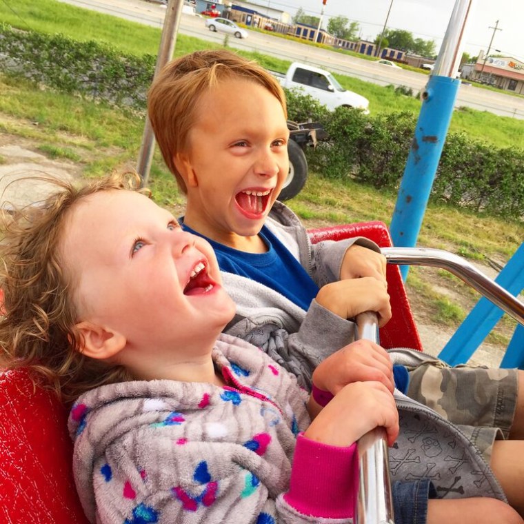 Lane's son, Lliam, 7, who is also deaf, enjoys a carnival ride with sister Dewana, 3.