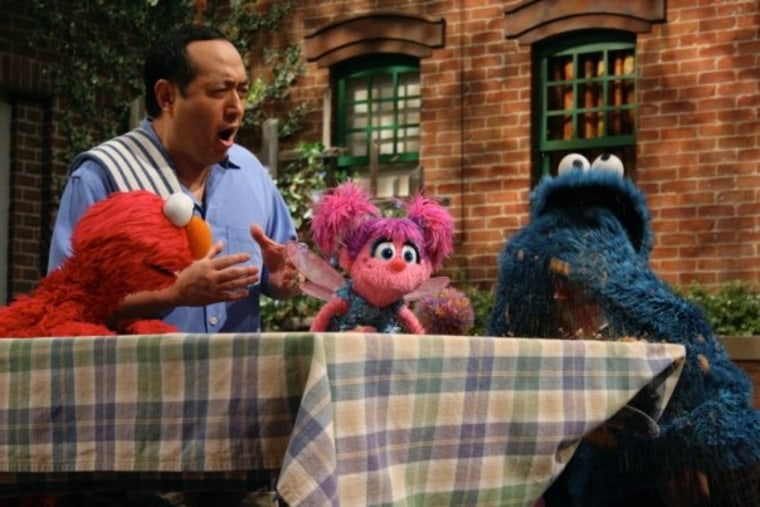 Alan Muraoka with Elmo, Abby, and Cookie.