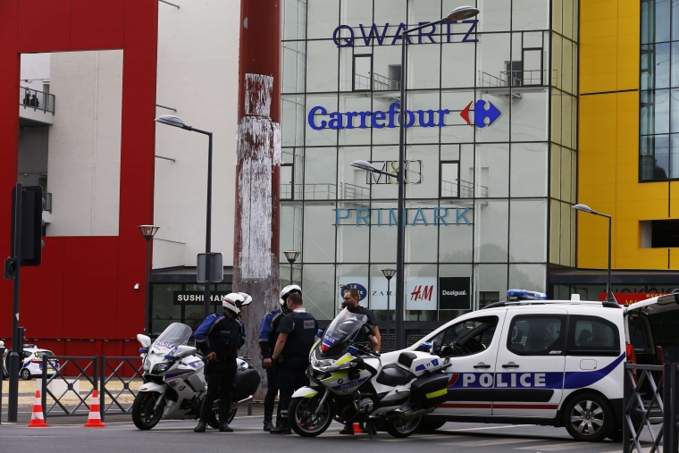 Image: Police officers stand outside the Qwartz mall
