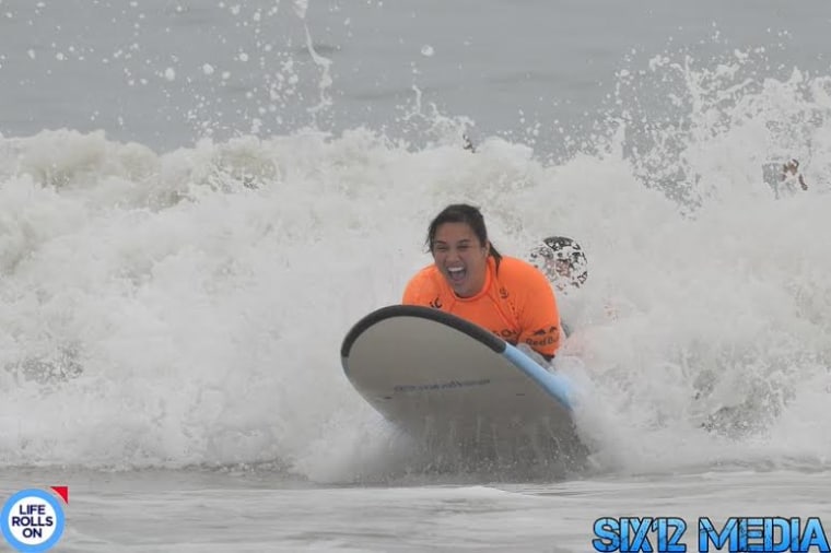 Image: Theresa de Vera surfs for the first time with Life Rolls On.