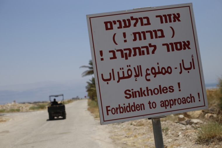 A sign warns of sinkholes at the closed Mineral Beach resort on the Israeli side of the Dead Sea.