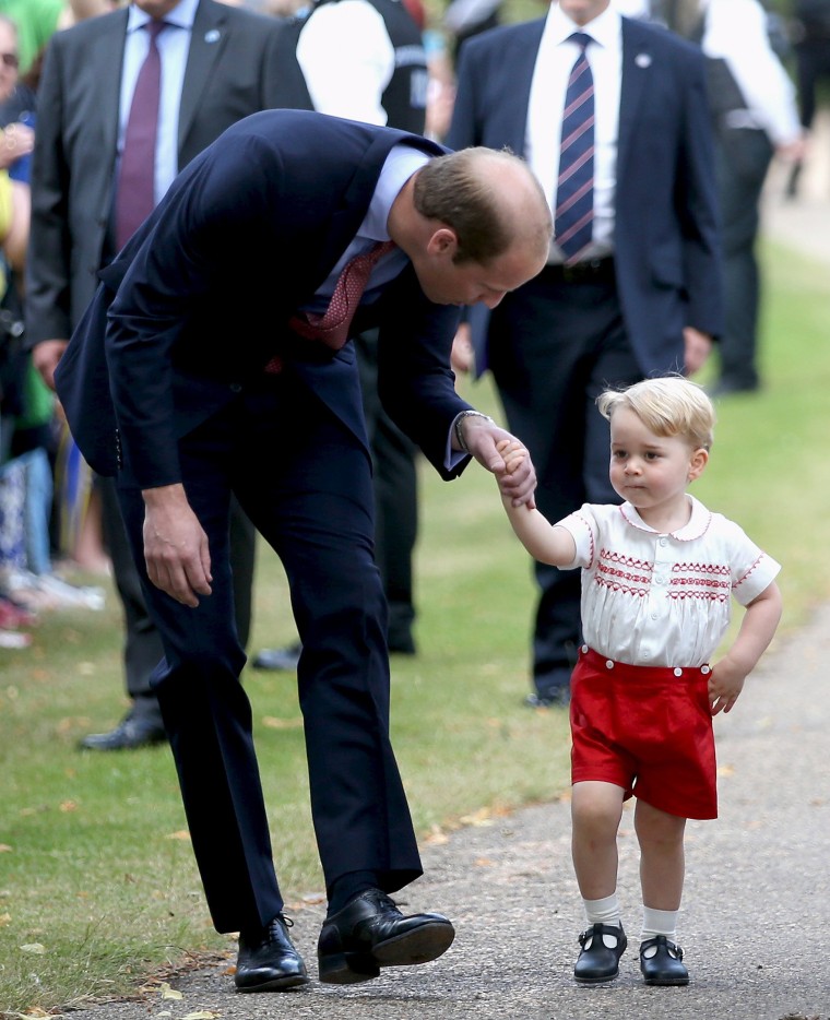 Prince William, Duke of Cambridge speaks with Prince George of Cambridge as they arrive at the Church of St Mary Magdalene on the Sandringham Estate for the Christening of Princess Charlotte of Cambridge