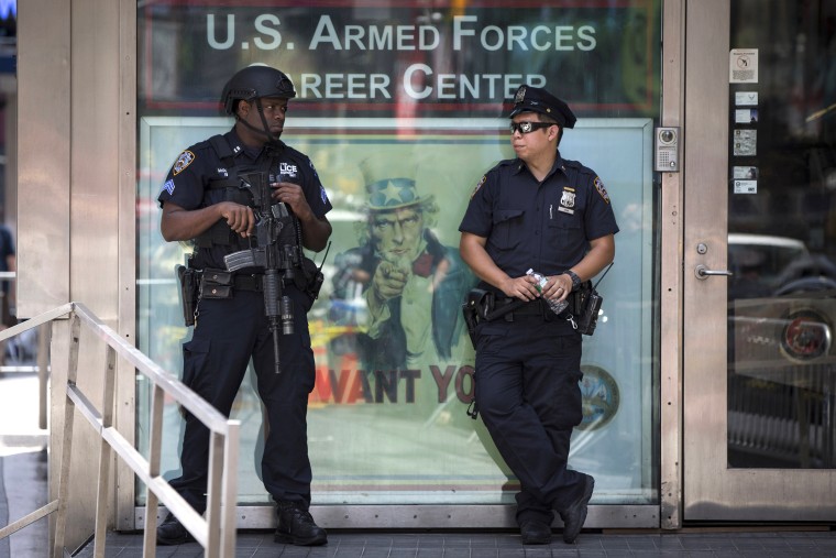 Image: Police officers, one a member of a “Hercules” team, left,  stand guard outside the Times Square Armed Forces Recruiting Station, a day after a gunman killed four Marines in Tennessee in an attack on two military sites, in New York.