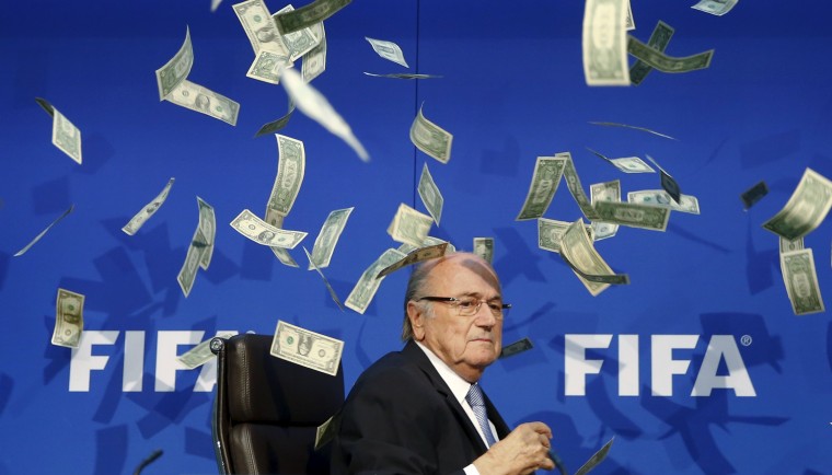 Image: British comedian known as Lee Nelson (unseen) throws banknotes at FIFA President Blatter as he arrives for a news conference after the Extraordinary FIFA Executive Committee Meeting at the FIFA headquarters in Zurich