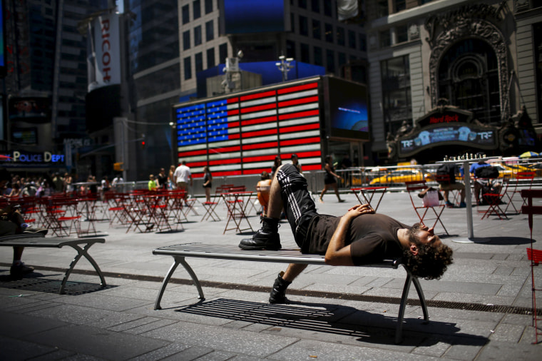 Image: A man takes a nap during a sunny day at Times Square in New York